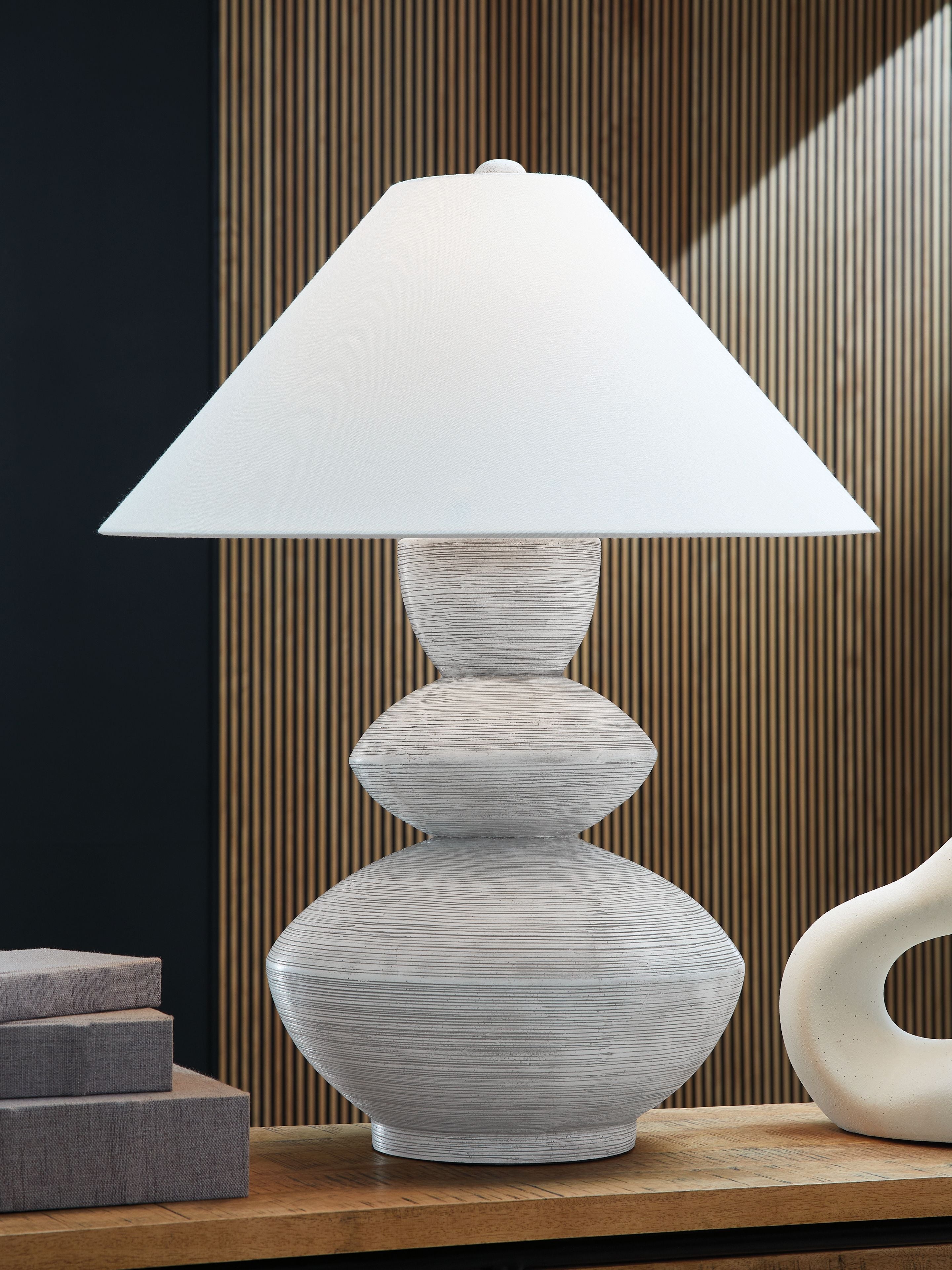 Distressed white table lamp with wide drum shade and sculpted round base