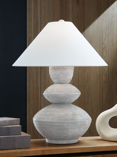 Distressed white table lamp with wide drum shade and sculpted round base
