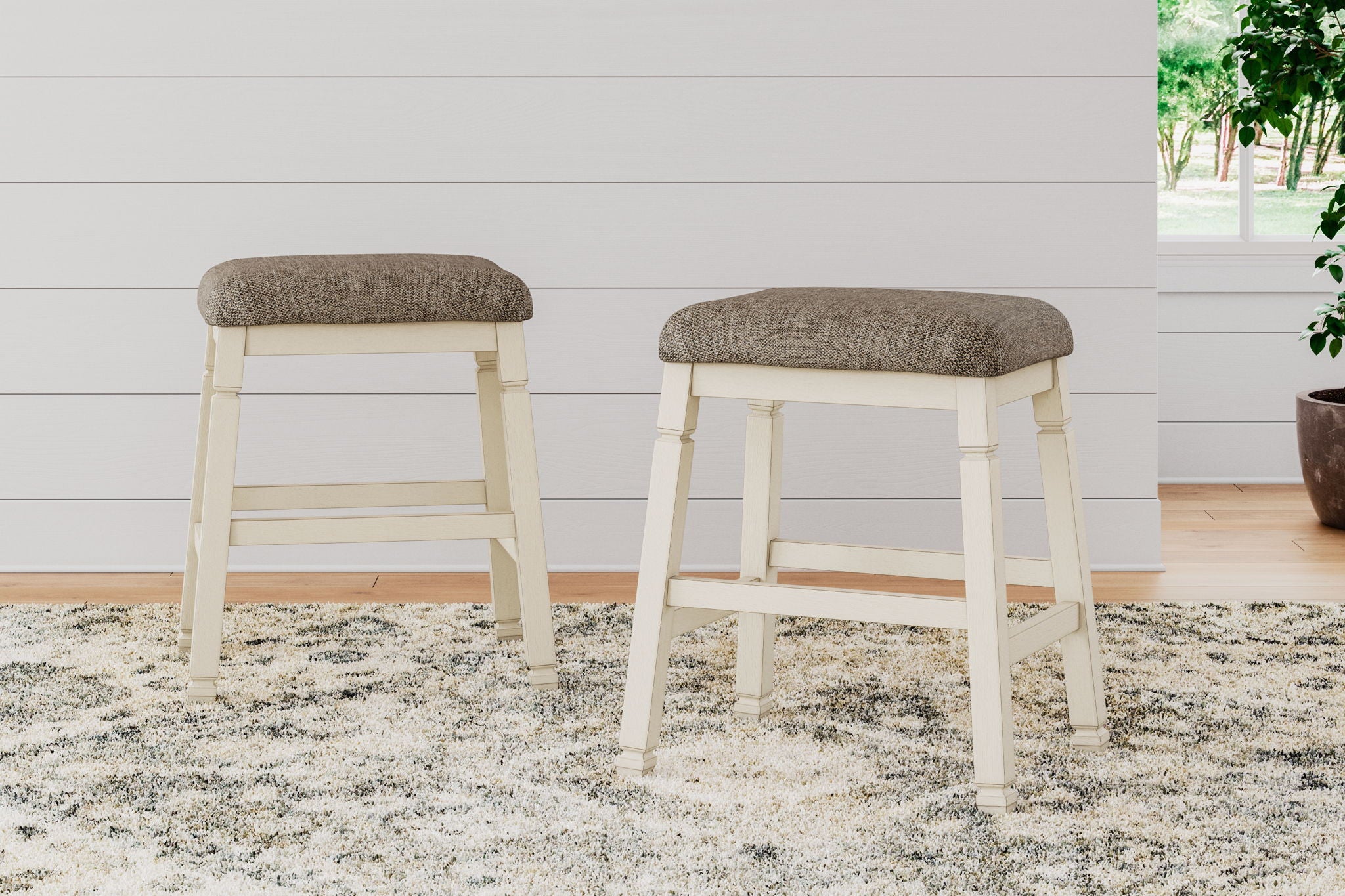 Set of 2 upholstered stools with textured neutral fabric seats and light wood frames
