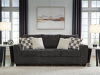 Gray upholstered sofa with patterned and white accent pillows