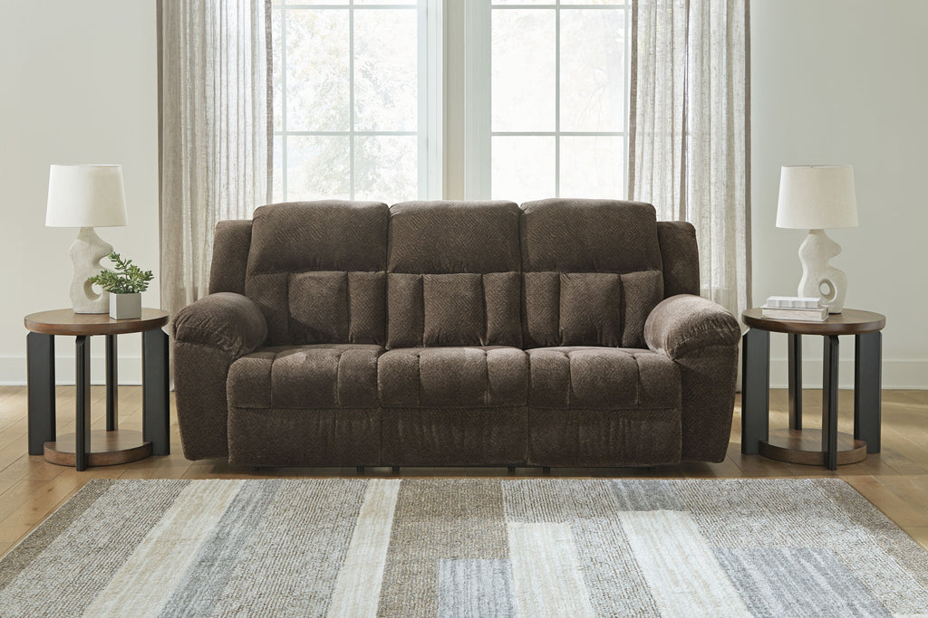 Dark brown reclining sofa with tufted back panels, rounded arms, and cushioned seat