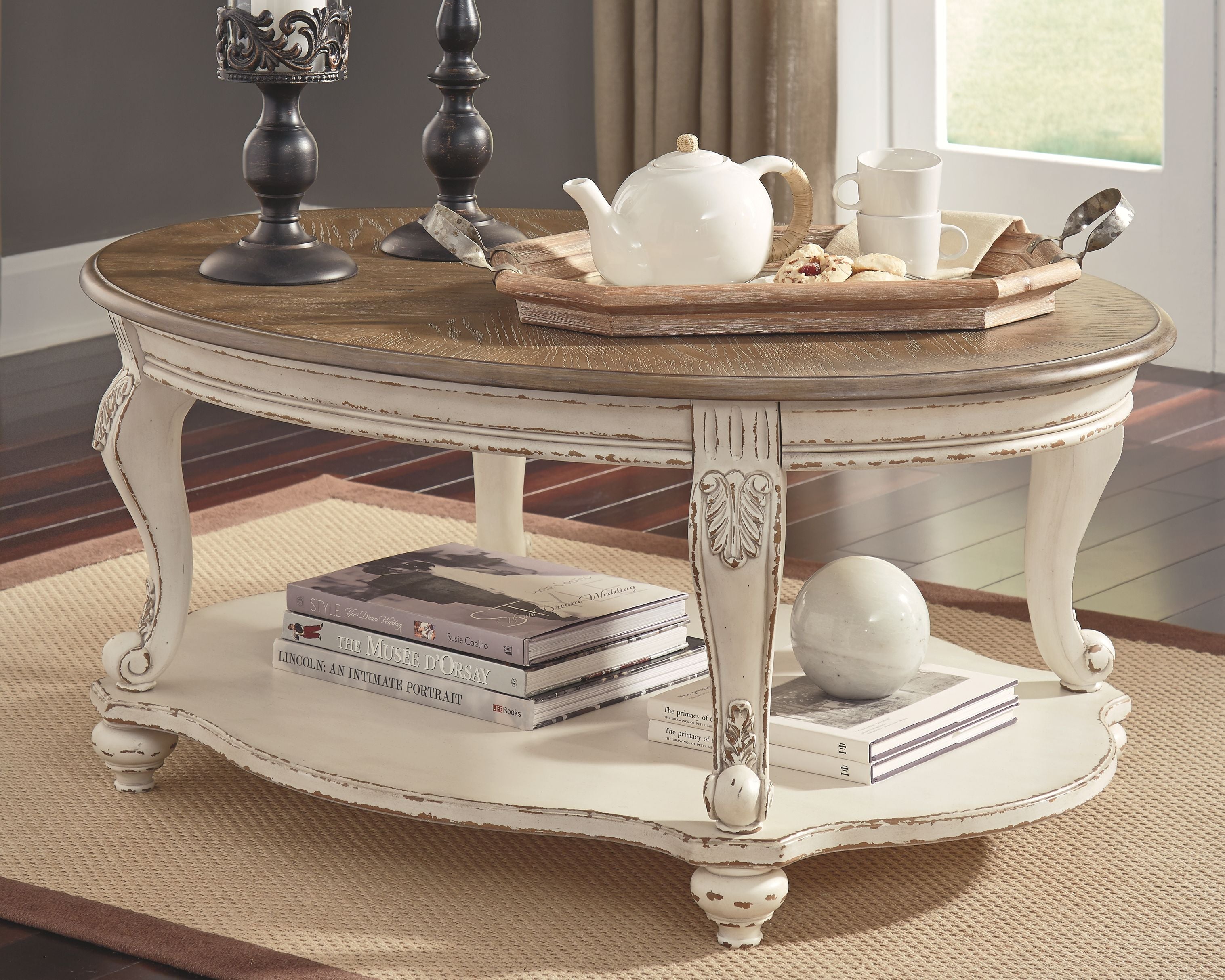 Oval cocktail table with white distressed base and brown oval tabletop