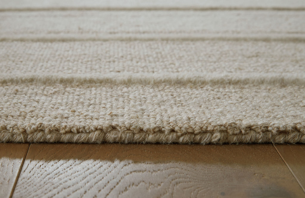 Beige rug pile close-up with textured weave and light border line