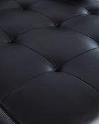 Dark sofa upholstery detail with quilted seam lines across padded cushions