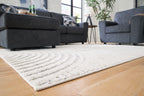 Light gray area rug with wave-and-arch motif and textured low pile