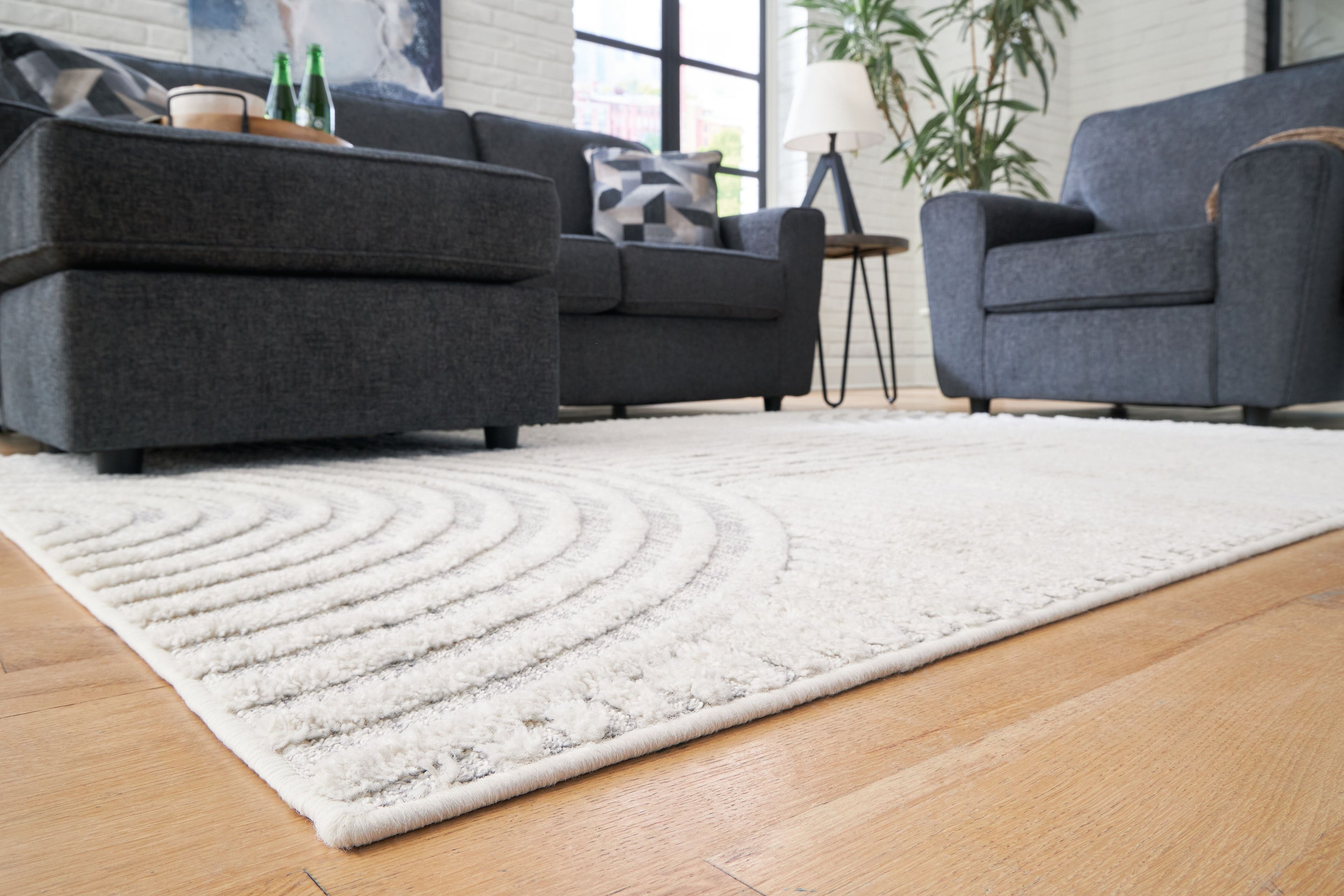 Light gray area rug with wave-and-arch motif and textured low pile