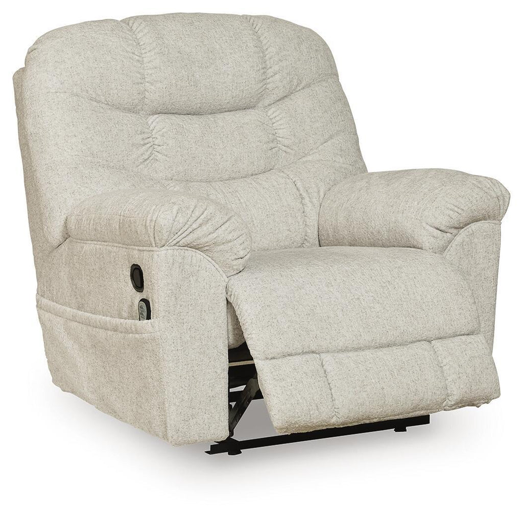 Light beige upholstered recliner with thick headrest, button-tufted back, and angled seat