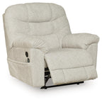 Light beige upholstered recliner with thick headrest, button-tufted back, and angled seat