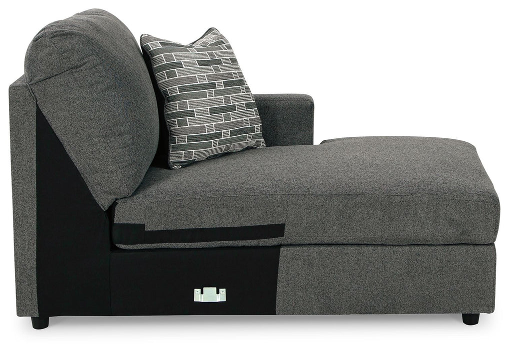 Dark gray corner chaise with rounded arm and patterned throw pillow