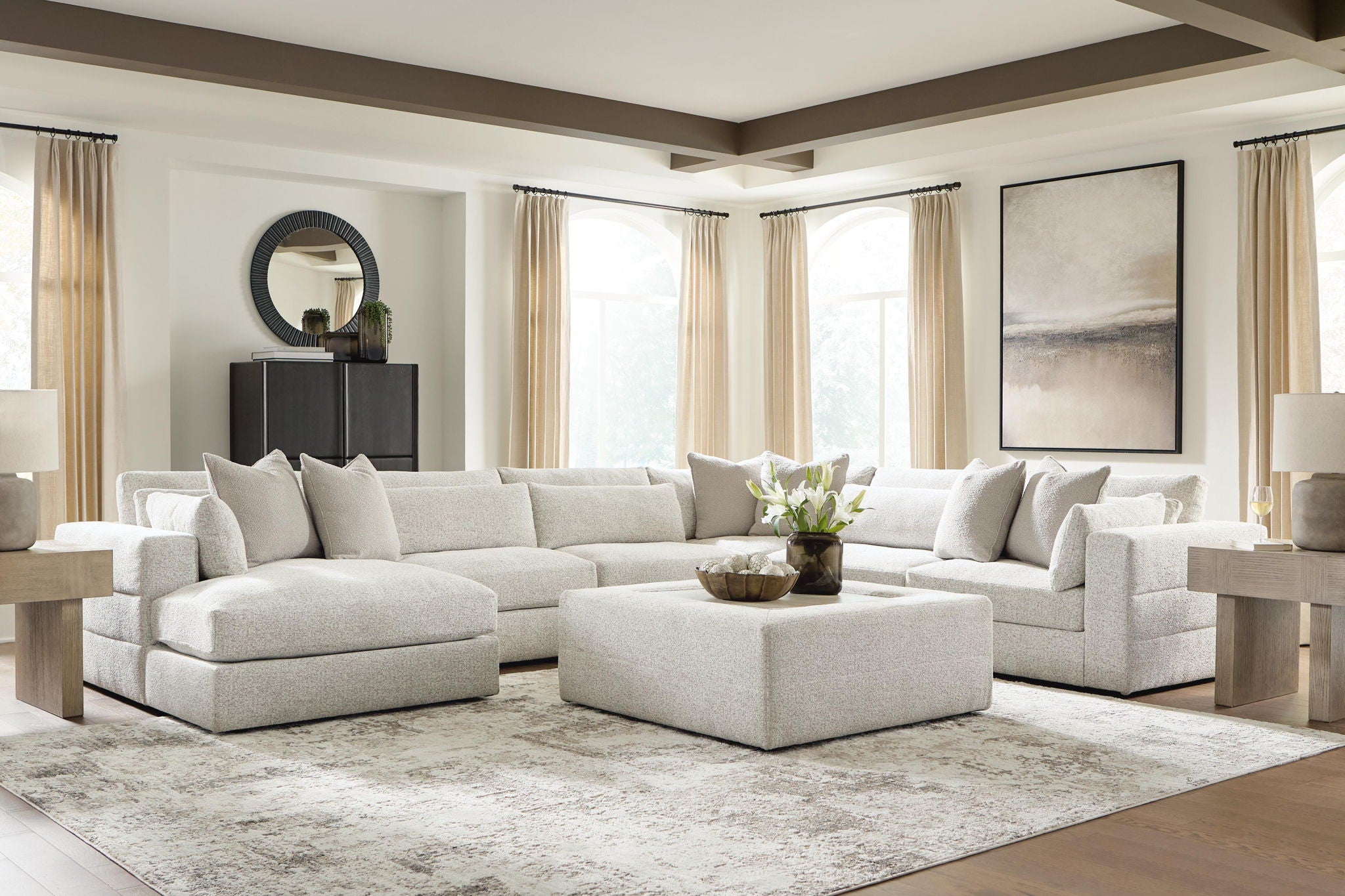 Beige sectional sofa with chaise lounge, multiple seat sections, and decorative throw pillows