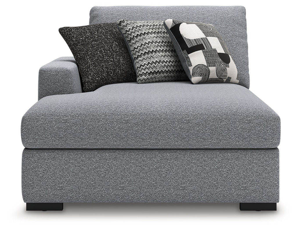 Grey upholstered chaise with back cushions and decorative throw pillows