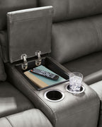 Power reclining sectional sofa console with cup holders and control switches on the arm