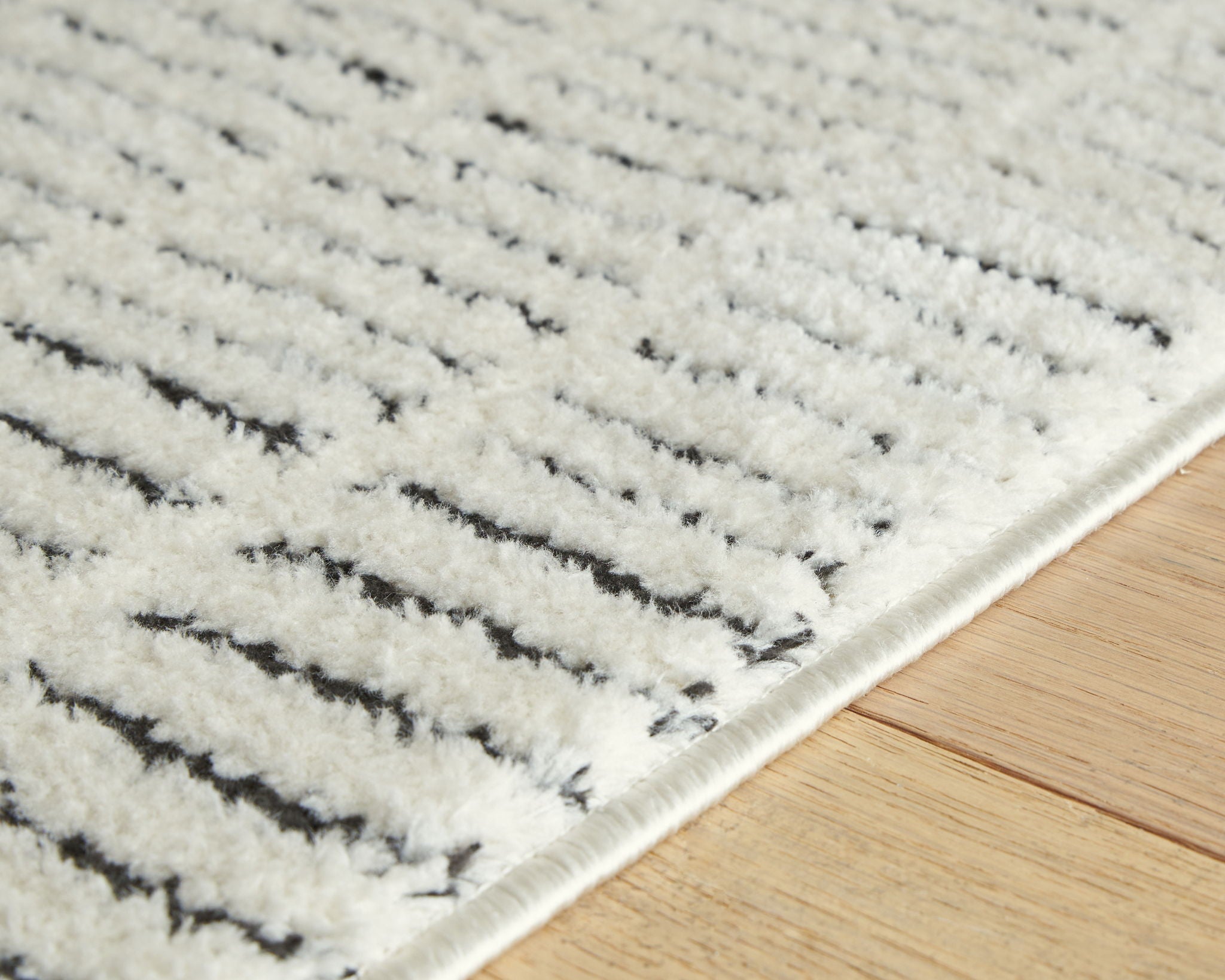 Turinwith rug detail, textured beige pile with black stripe bands