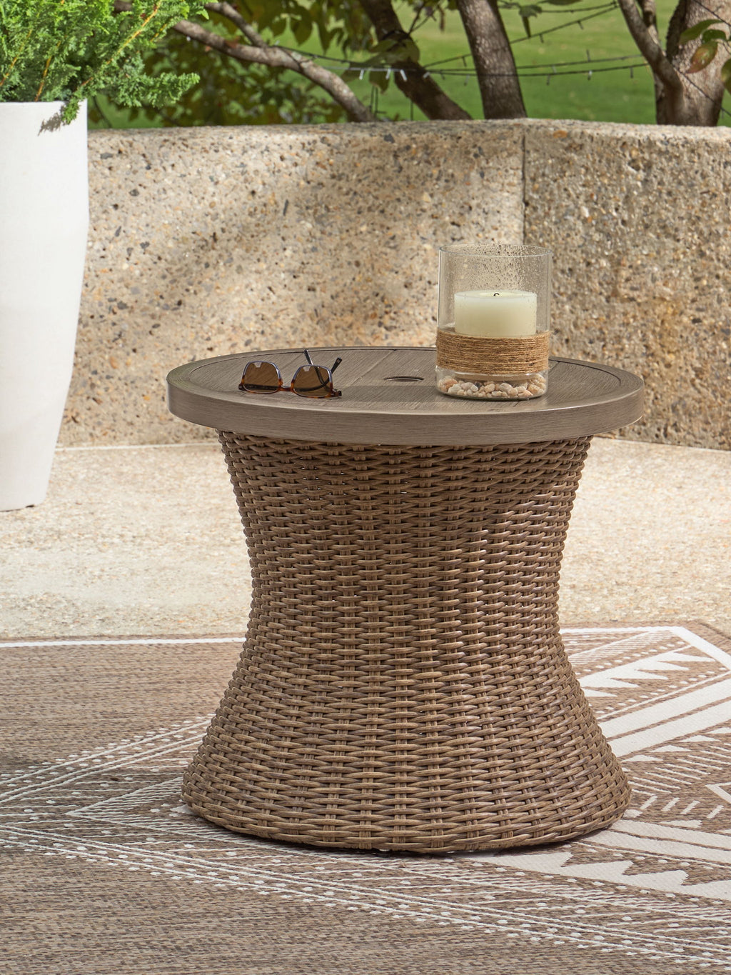 Round end table with beige woven base, tabletop umbrella accessory and tray