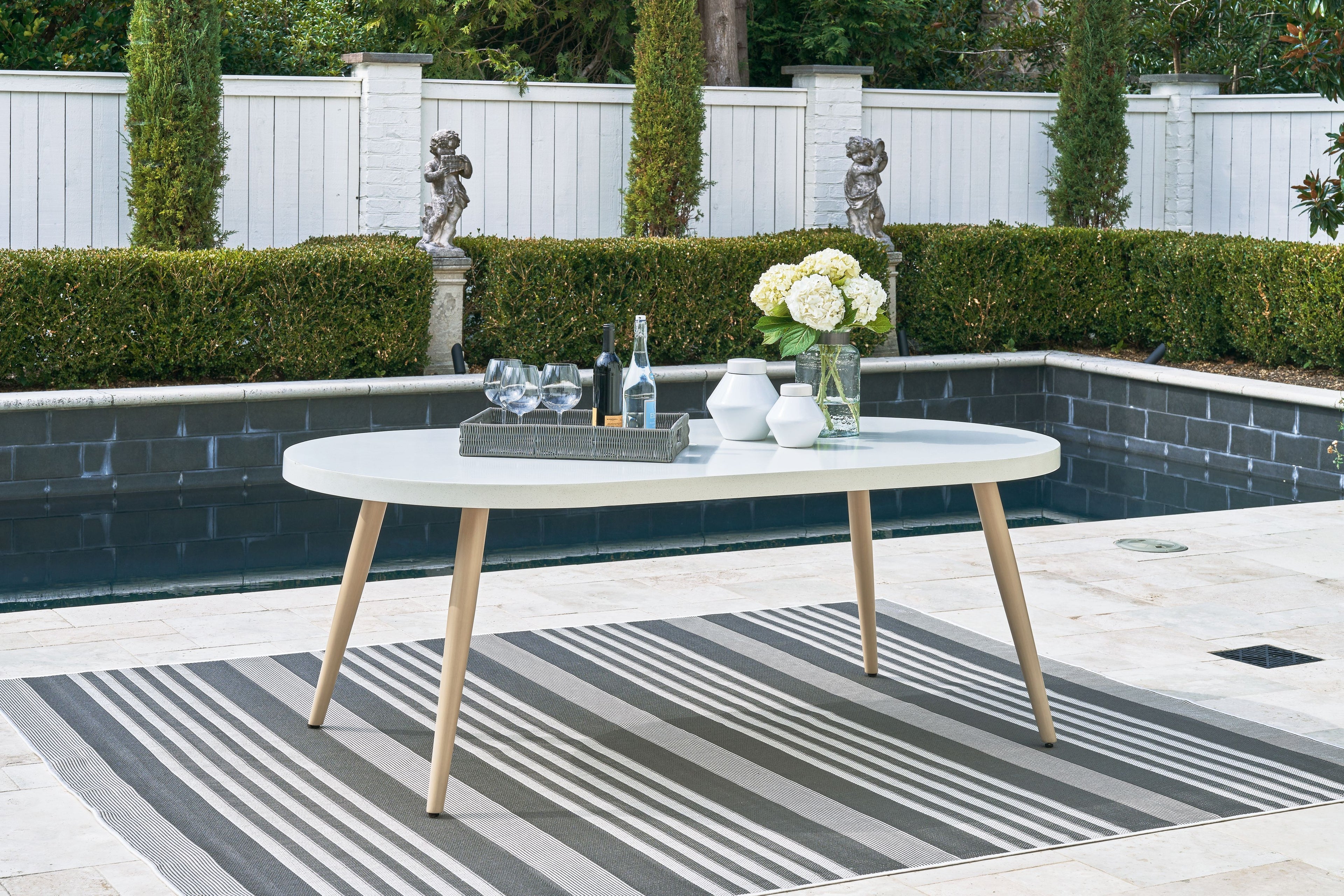 White oval dining table with tapered legs and oval tabletop