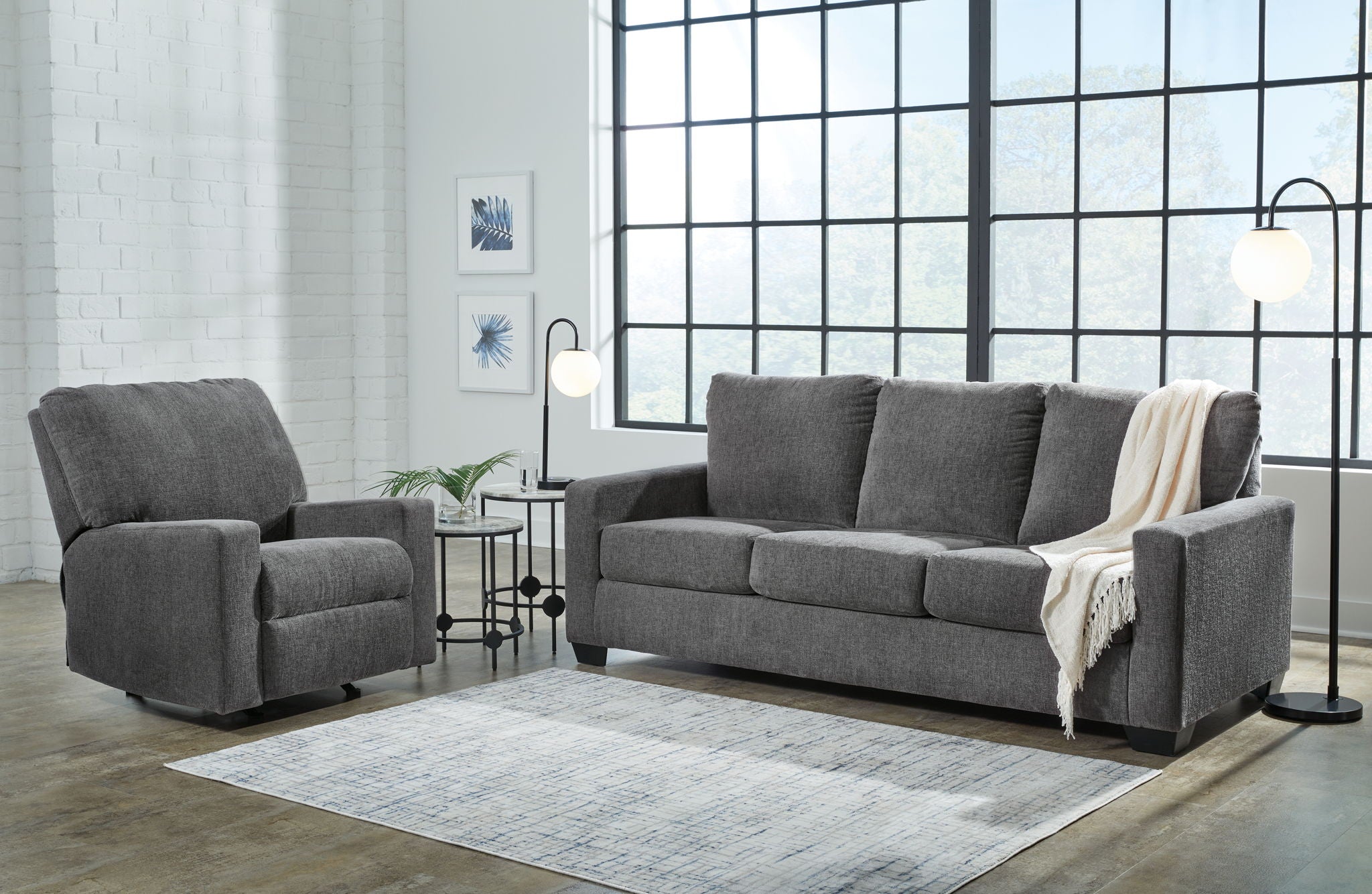 Charcoal gray sofa set with matching armchair and a light throw blanket