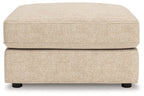 Sand fabric ottoman with low rectangular base, smooth top, and dark legs