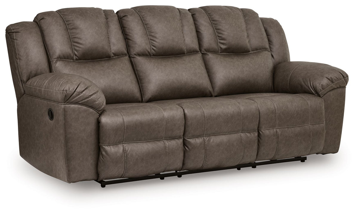 Dark brown reclining sofa with tufted back cushions, padded arms, and split seat panels
