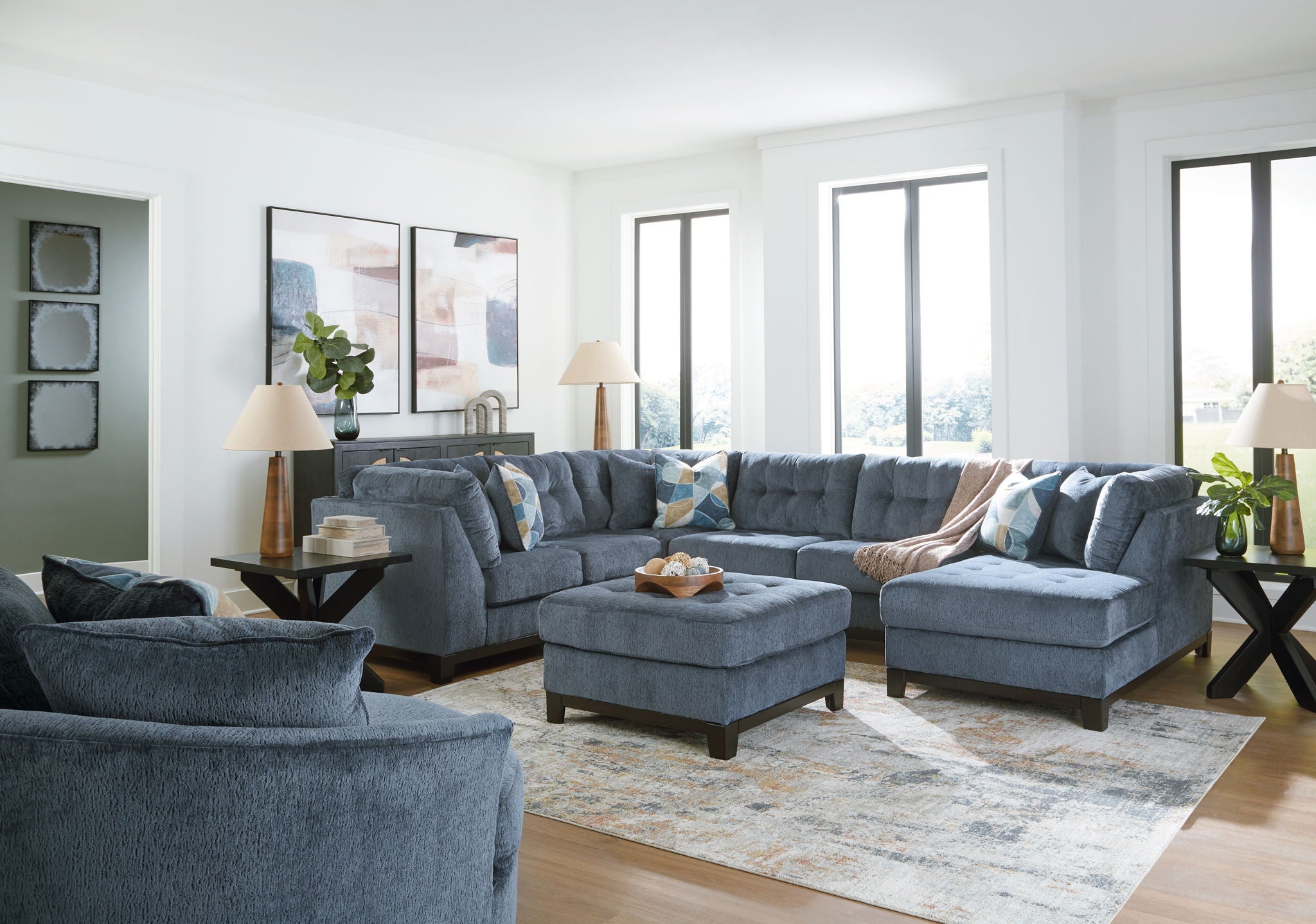 Blue living room sectional set with chaise and ottoman on a light rug