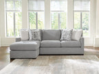 Dark gray sleeper sectional sofa with chaise seat and three geometric accent pillows