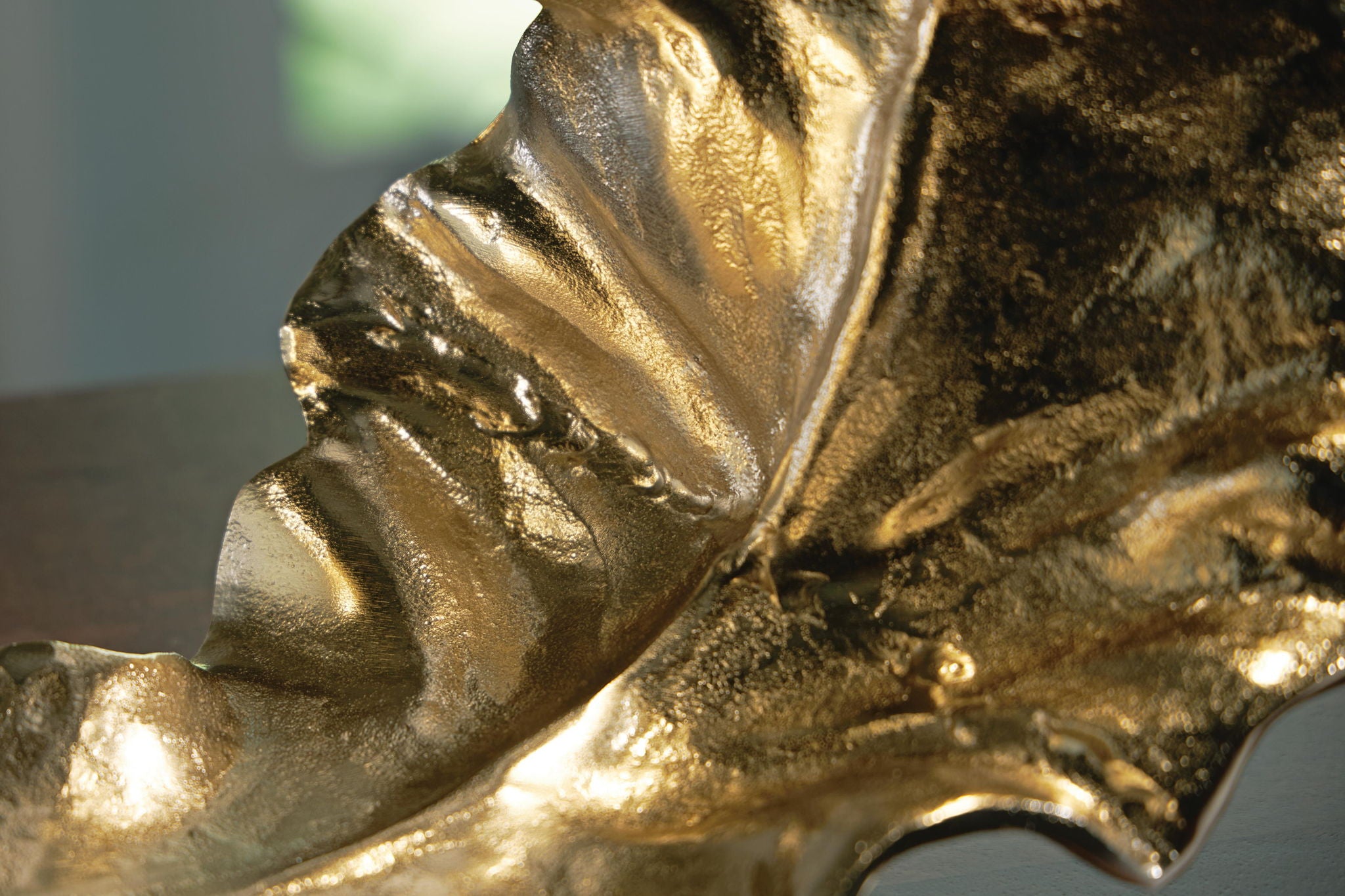 Close-up gold and silver metal sculpture, crinkled ridges and highlights