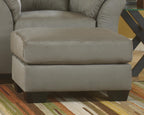 Upholstered ottoman in light gray fabric, padded top and side panels.