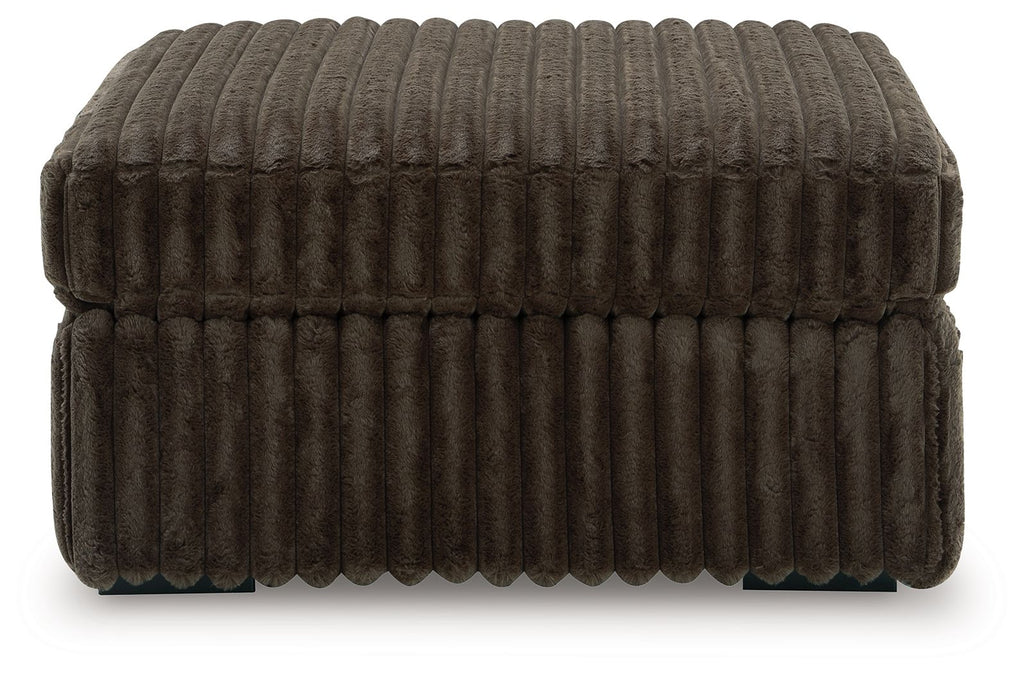 Oversized accent ottoman in taupe-brown, ribbed upholstery, tufted edges