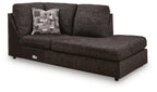Corner chaise sofa, dark textured fabric, tufted arms, patterned throw pillow, block legs