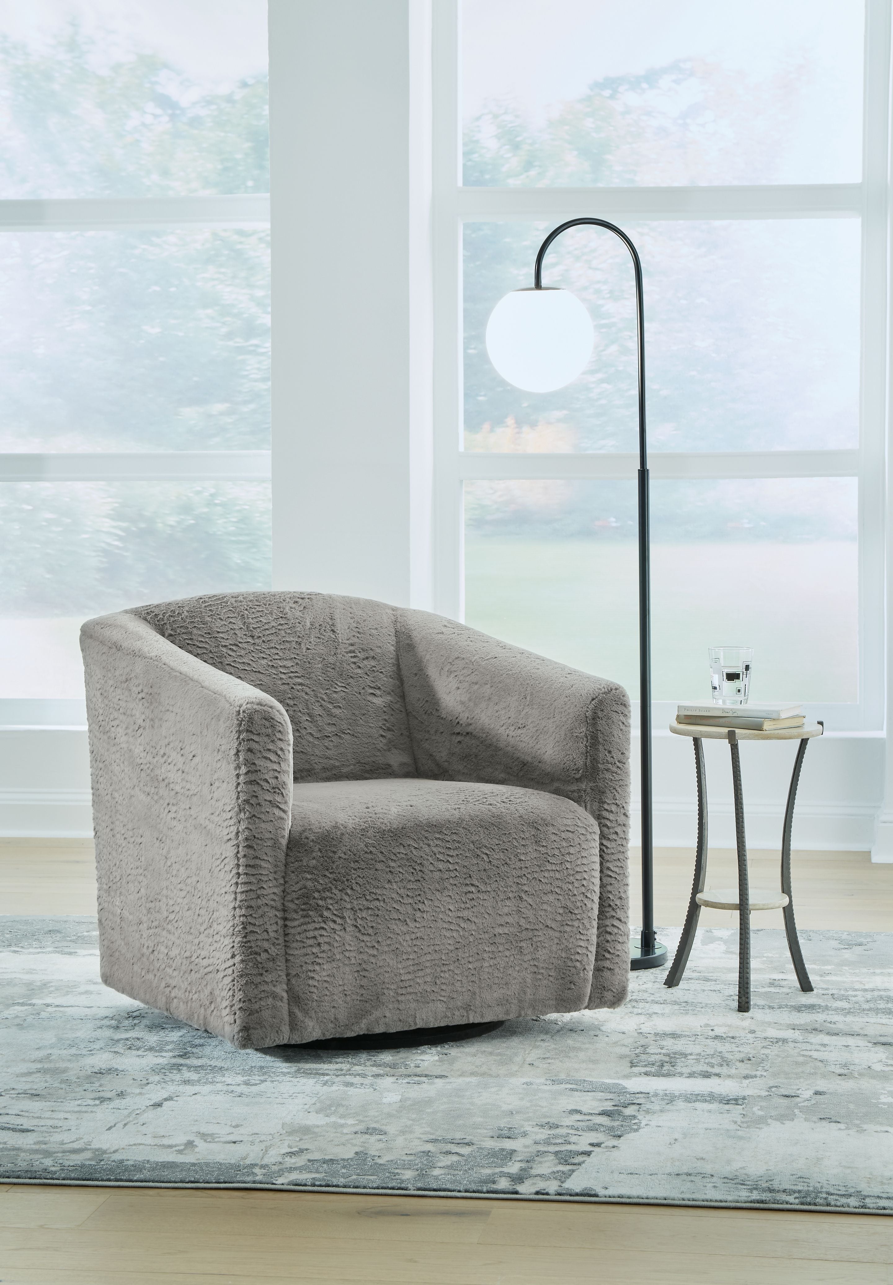Textured charcoal gray swivel accent chair with rounded arms and back, low profile