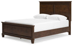 Dark brown panel bed with white mattress and two pillows, side view.