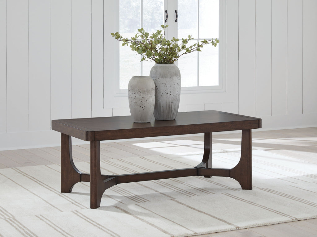 Dark brown rectangular cocktail table with curved apron and sturdy block legs