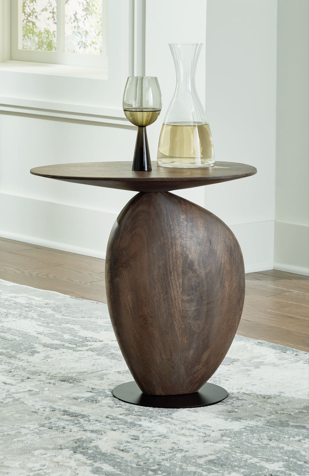 Accent table with dark brown round top and tall pedestal, black base ring