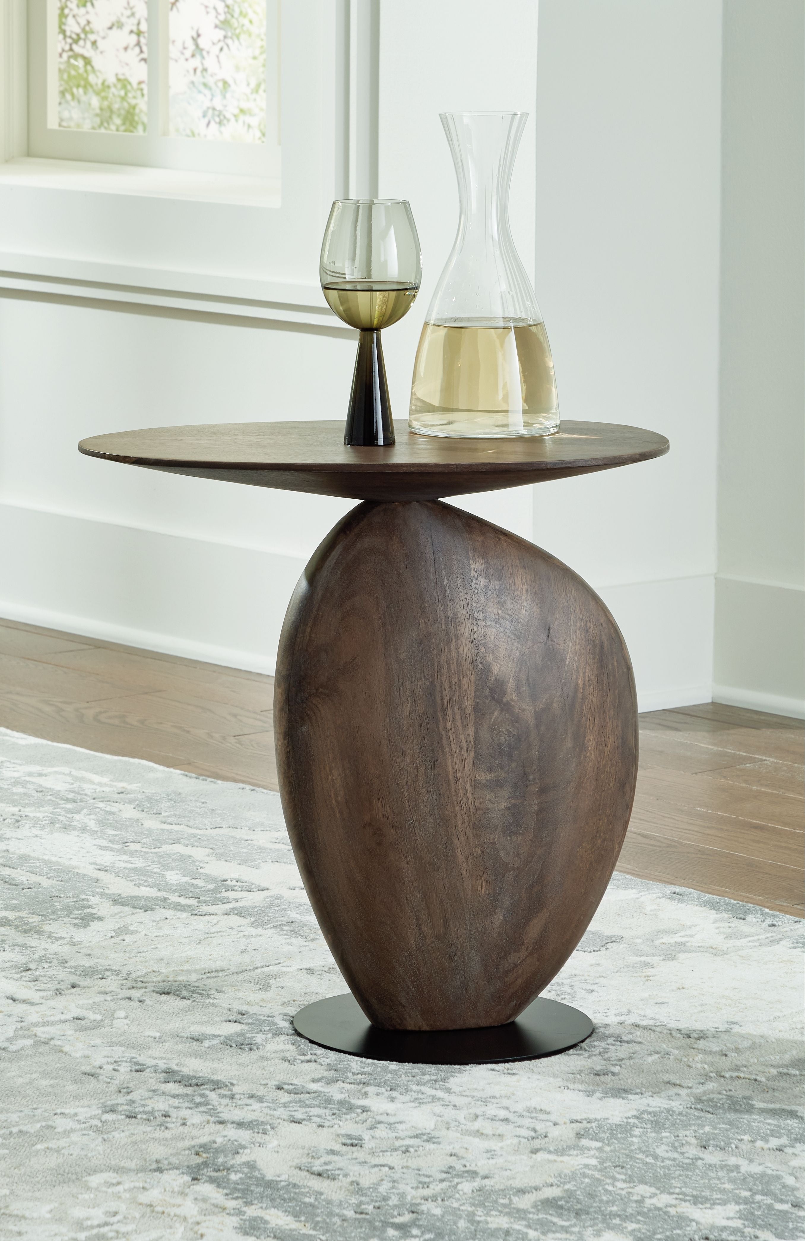 Accent table with dark brown round top and tall pedestal, black base ring