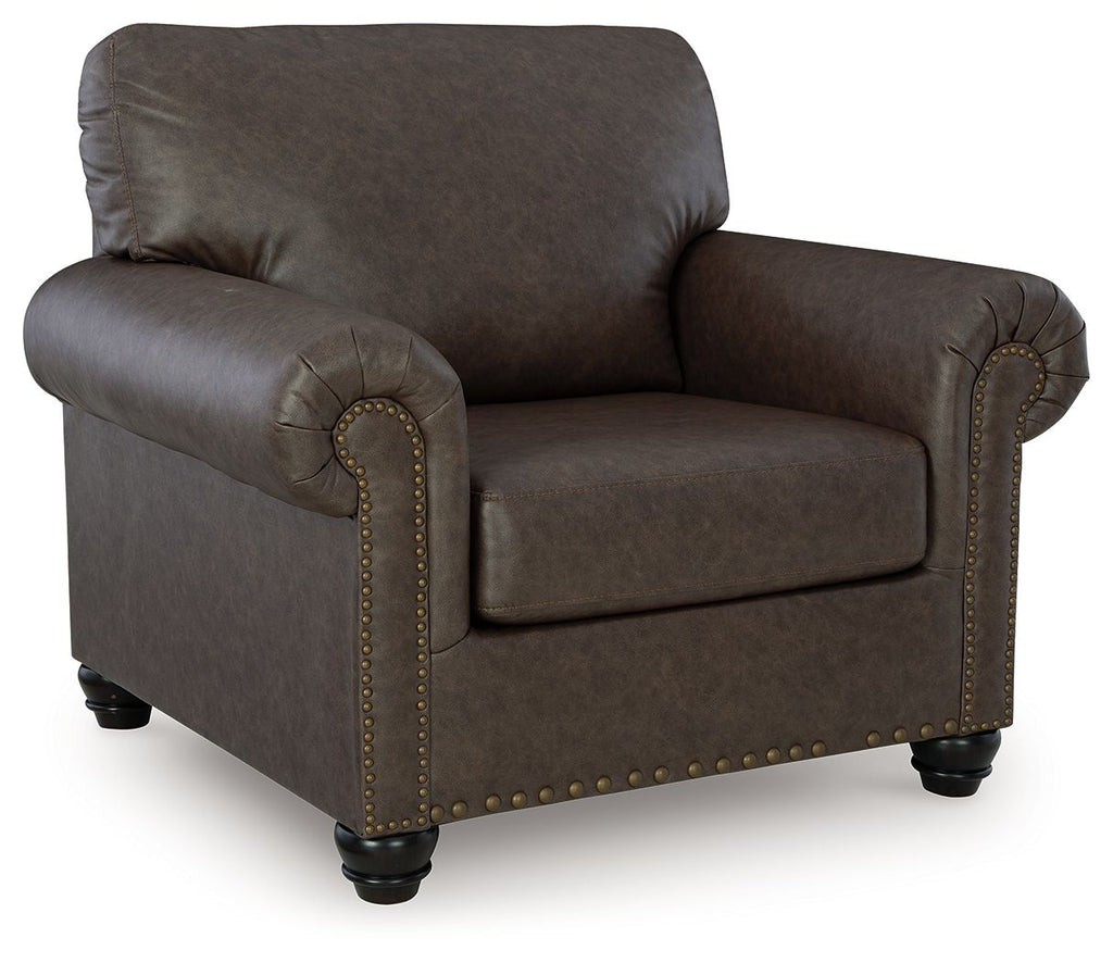 Dark brown upholstered living room chair with nailhead trim and rolled arms.