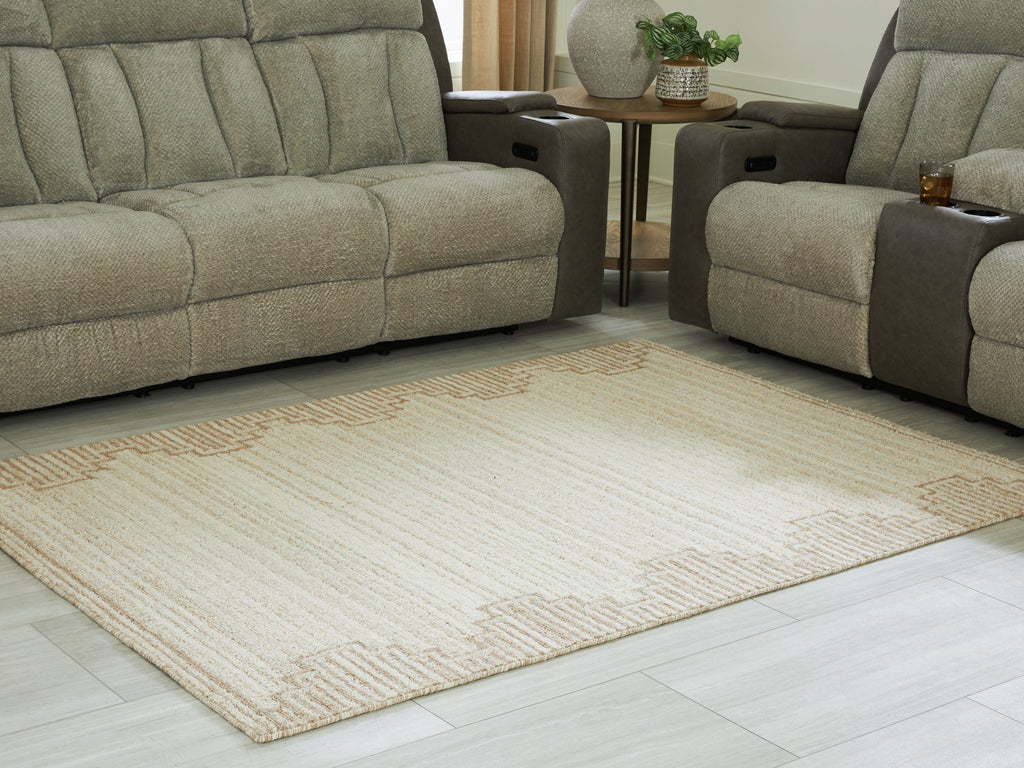 Beige area rug with geometric trim, placed on light wood flooring
