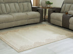 Beige area rug with geometric trim, placed on light wood flooring