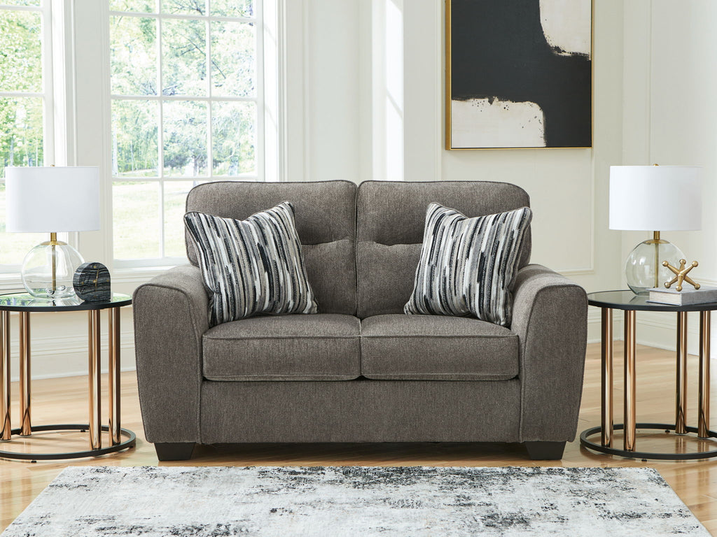 Dark gray upholstered loveseat with two seat cushions and striped throw pillows