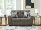 Dark gray upholstered loveseat with two seat cushions and striped throw pillows
