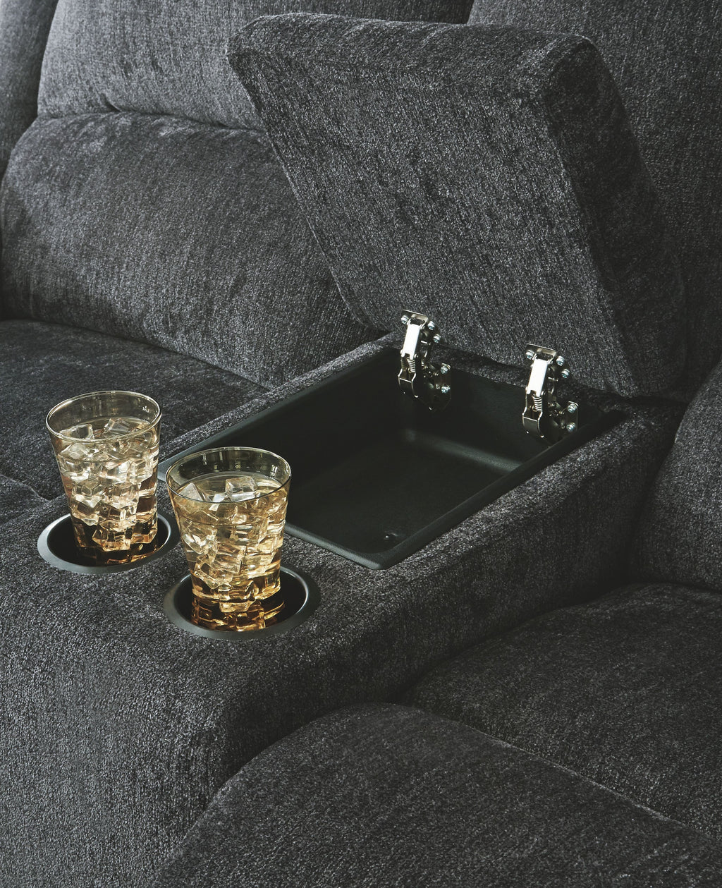 Dark gray reclining loveseat with built-in cup holder tray in the seat