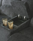 Dark gray reclining loveseat with built-in cup holder tray in the seat