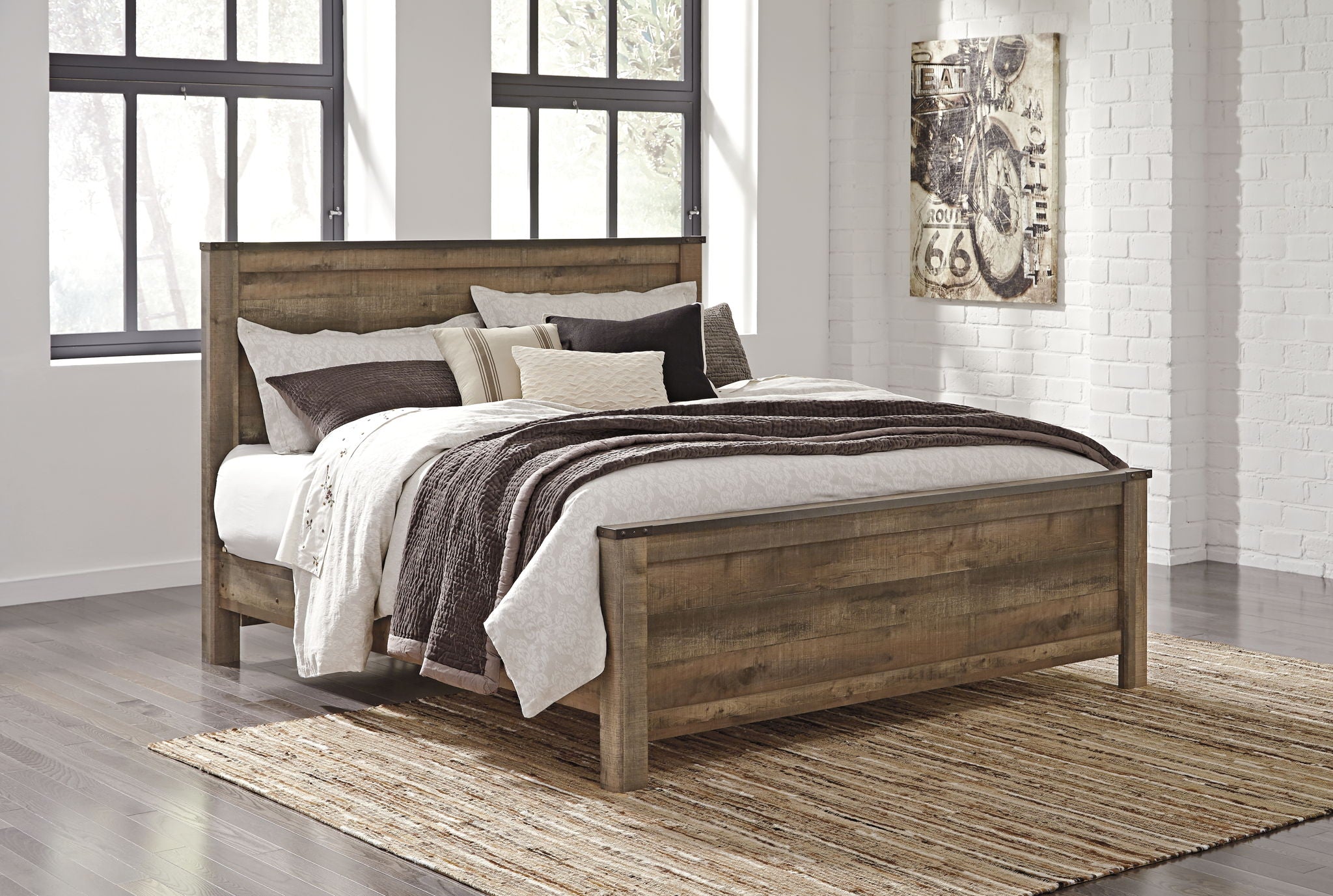 Panel bed with side drawers and neutral bedding with dark brown striped quilt and pillows