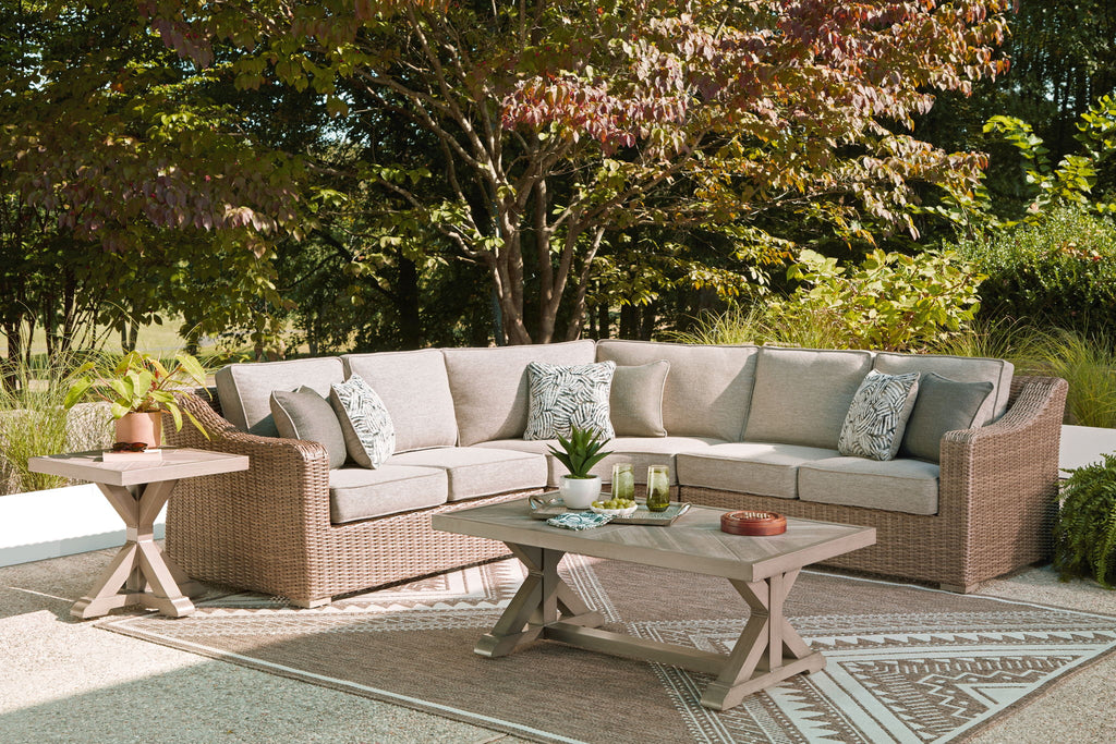 Outdoor sectional sofa with beige cushions and patterned throw pillows, with glass coffee table