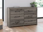 Six-drawer dresser with gray-brown wood finish and black bar pulls, side front view