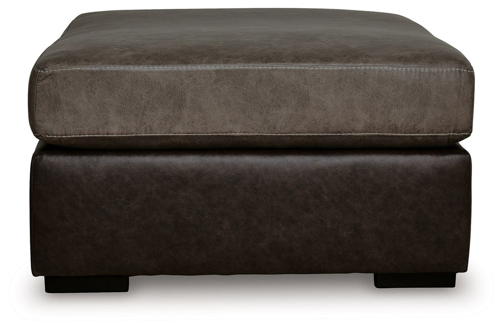 Oversized accent ottoman showing rounded upholstered arms and dark brown base.