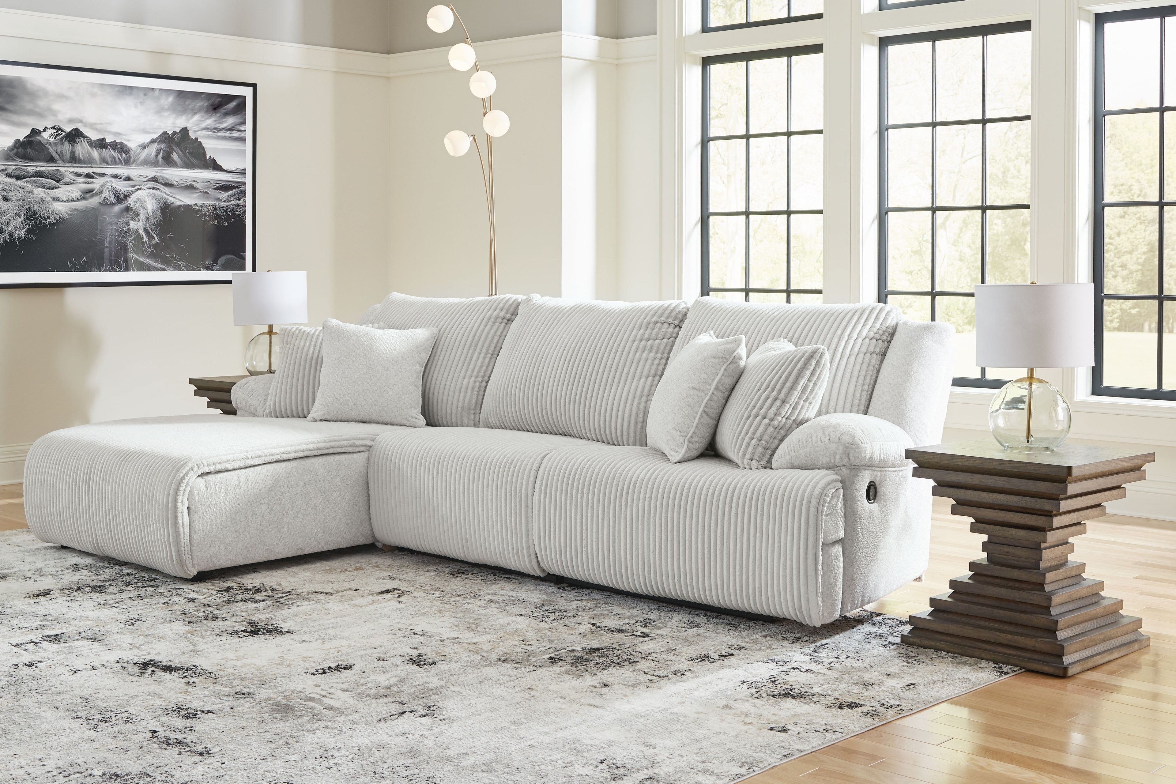 White ribbed reclining sectional sofa with chaise and multiple seat back pillows