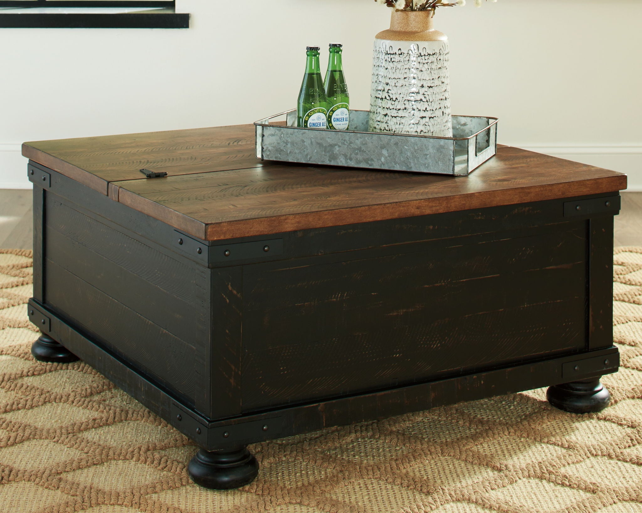 Lift-top cocktail table with brown tabletop and black lift base on carpet