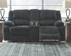Dark gray reclining loveseat with tall backrest, plush arms, and center console