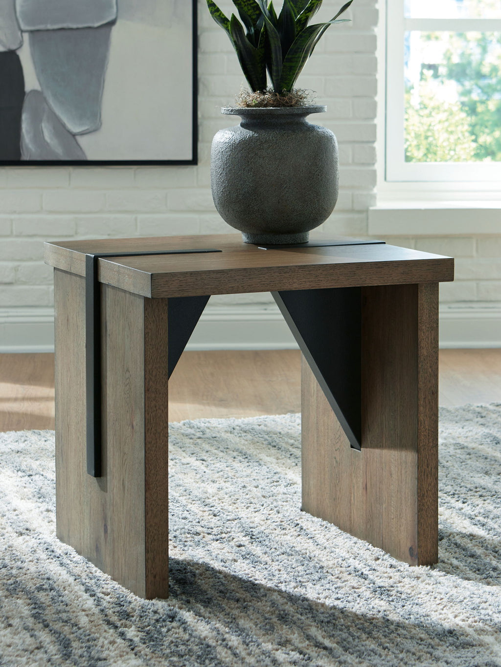 Light brown side table with black openwork supports and square tabletop