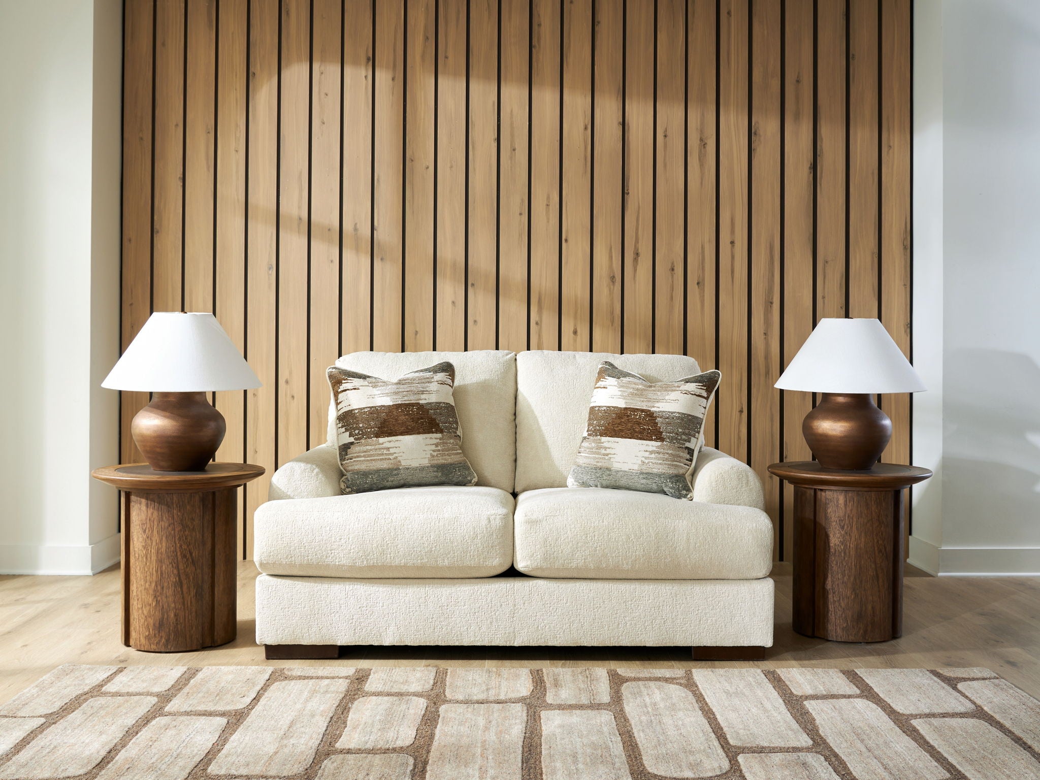 Cream loveseat sofa with two seat cushions and patterned throw pillows, square arms