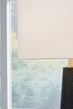 Black textured lamp body with brass collar and off-white shade edge